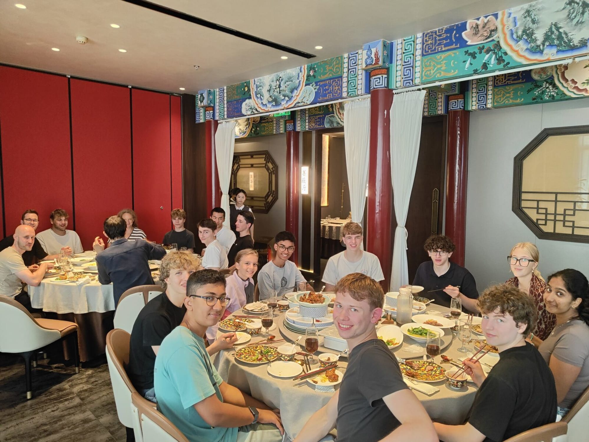 Lagergruppe lächelnd an runden Tischen in einem chinesischen Restaurant