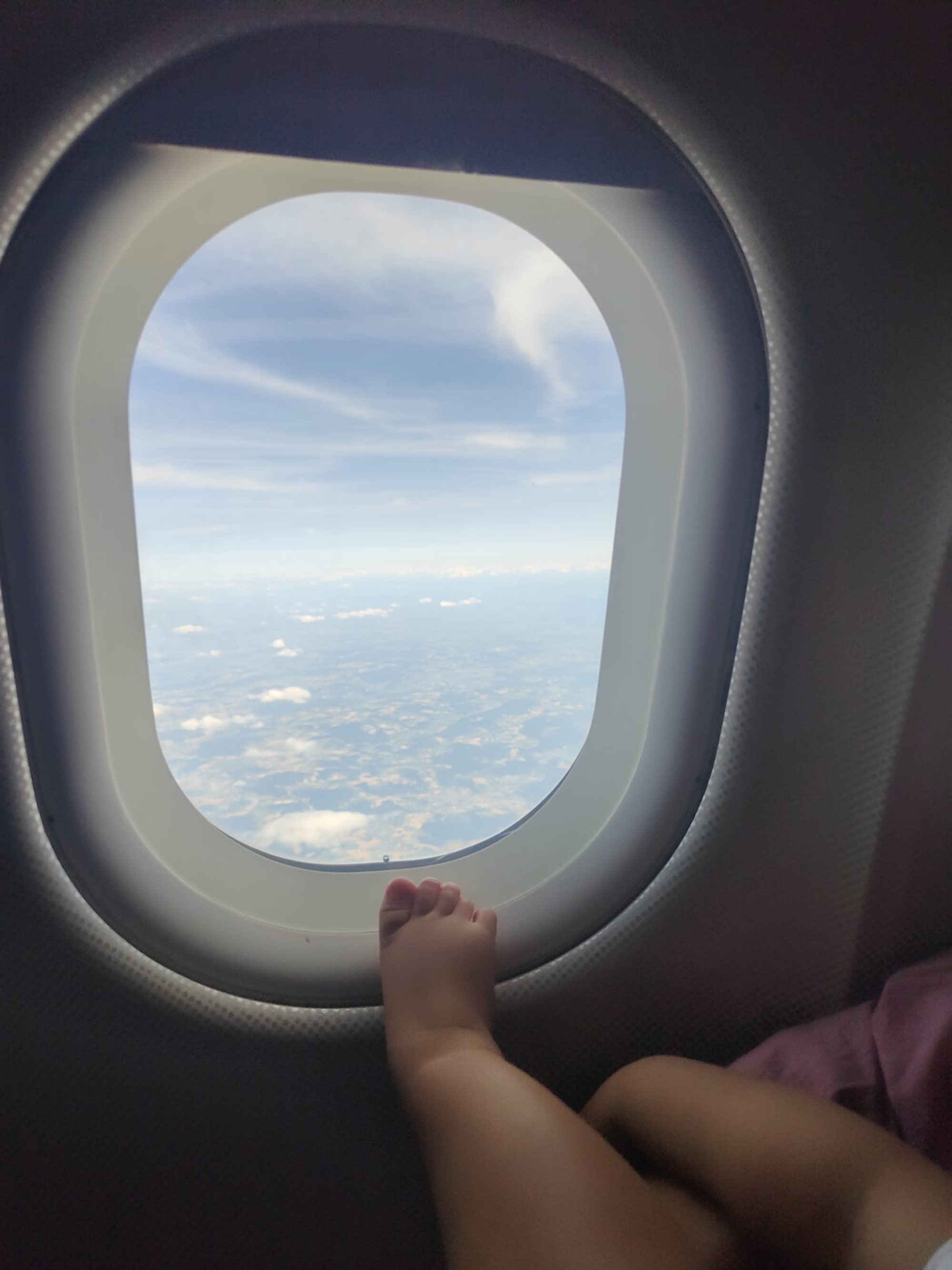 Blick aus dem Flugzeugfenster auf Wolken und Himmel