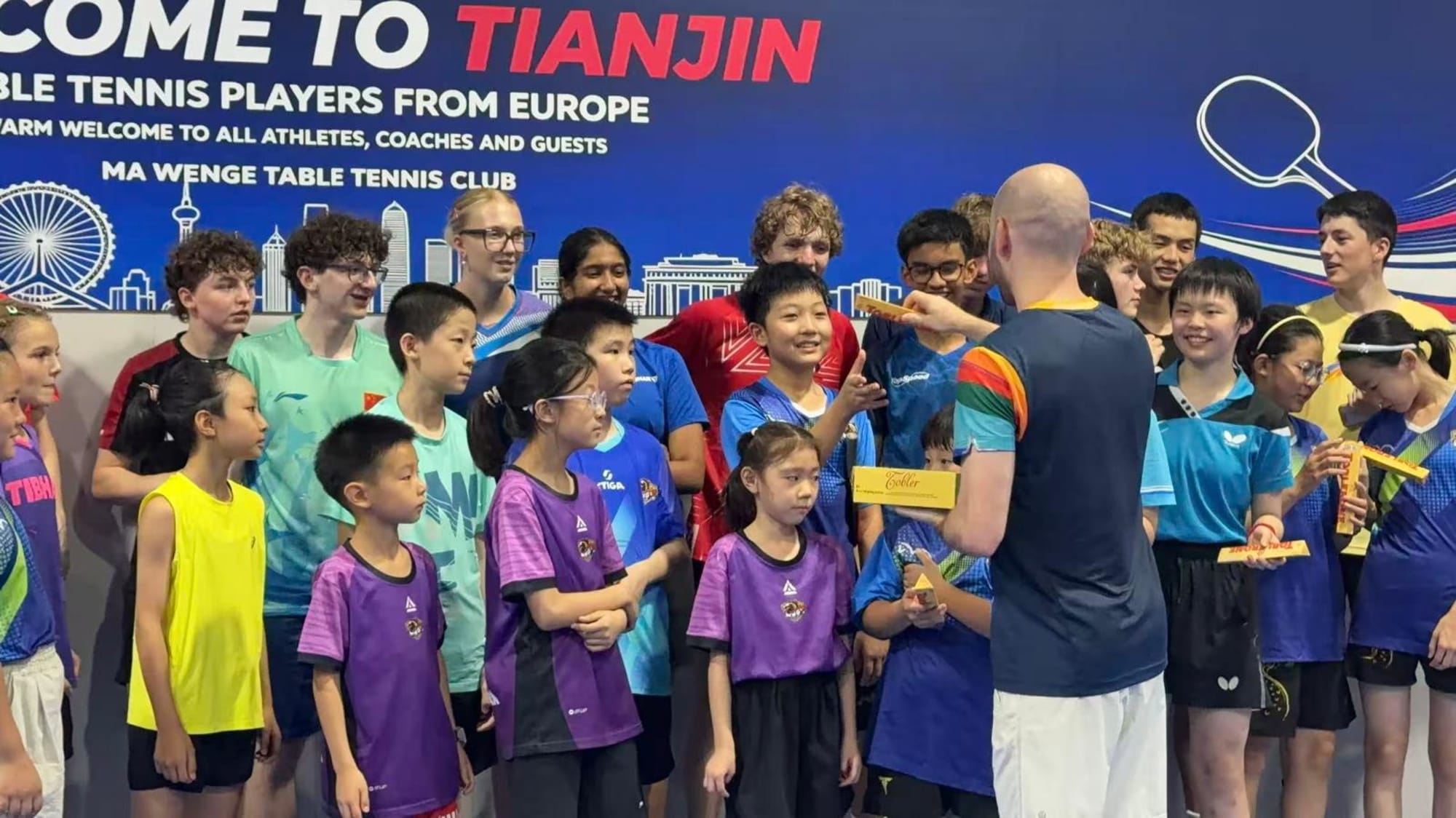 Toblerone-Verteilung vor dem Welcome-to-Tianjin-Banner