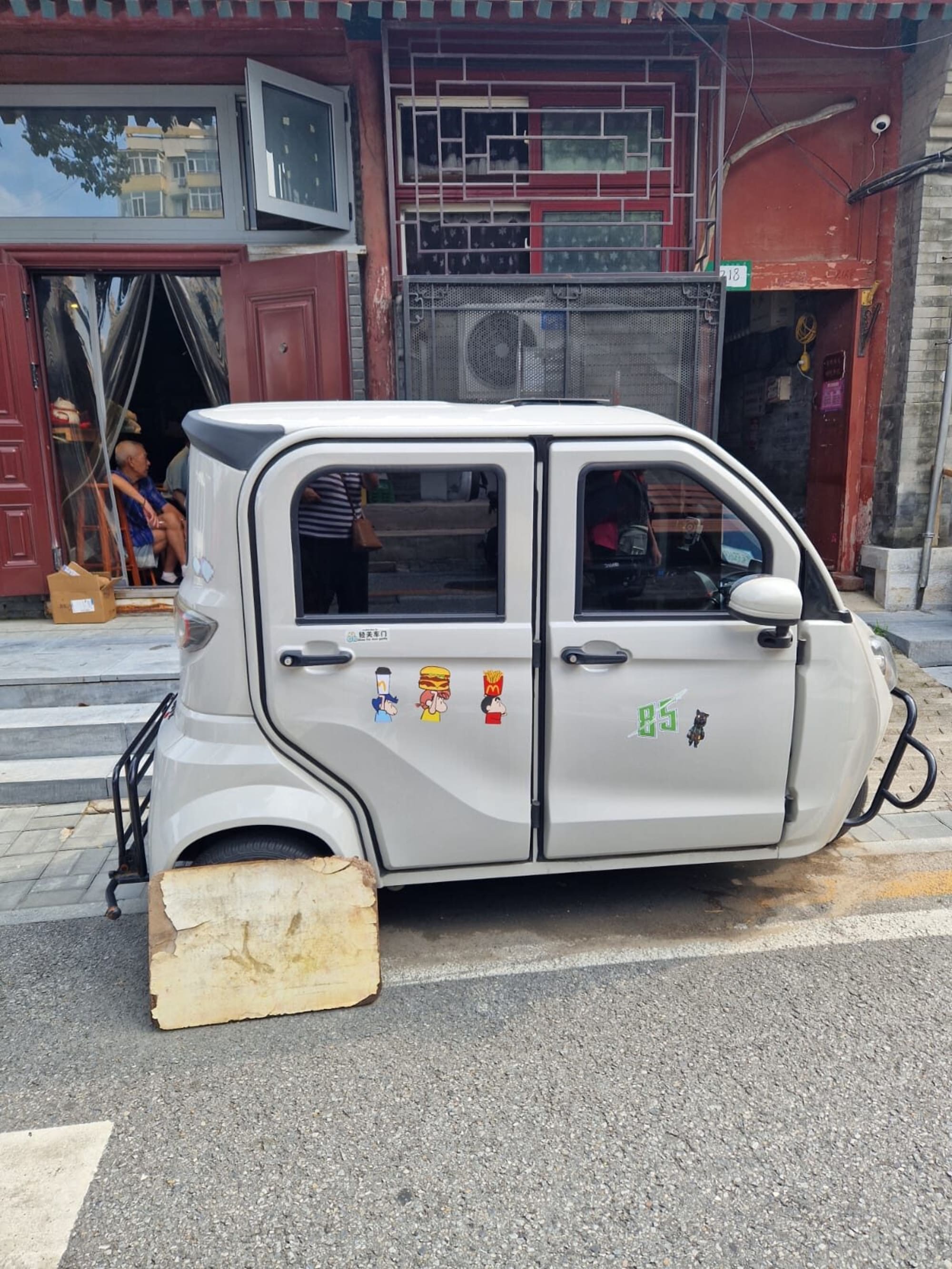 Kleines Dreirad-Auto mit Cartoon-Aufklebern